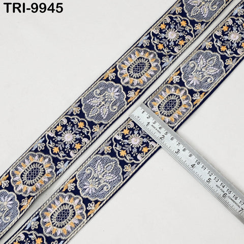a decorative fabric with a floral pattern, and a ruler is placed next to it, indicating the size of the fabric.