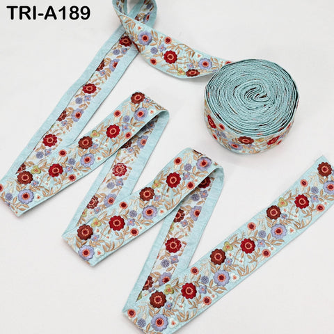 a collection of decorative fabric pieces, including a spool of blue fabric with a floral pattern and several pieces of fabric with a similar floral pattern.