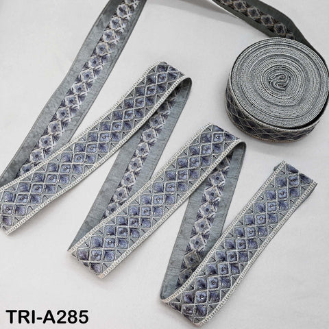 a collection of gray and white decorative fabric pieces, including a spool of thread and several spools of thread, arranged on a white background.