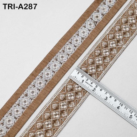 two pieces of decorative fabric with a repeating floral pattern, and a ruler is placed on top of one of the pieces to measure its length.