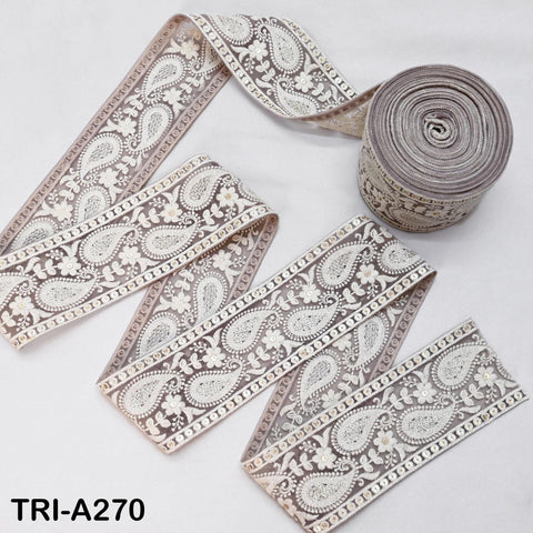 a roll of decorative fabric with a paisley pattern, placed on a white surface.
