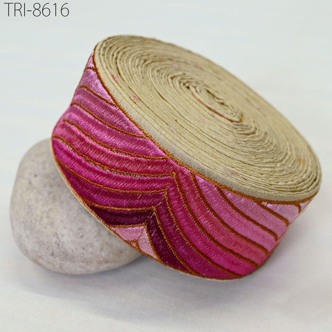 a decorative fabric with a pink and gold pattern, resting on a white surface.