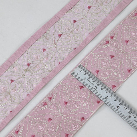 a close-up view of a pink and white fabric with a floral pattern, and a ruler is placed on top of it, indicating the size of the fabric.
