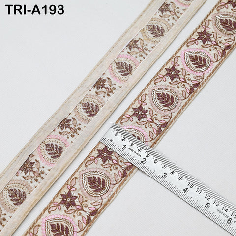 a decorative border with a repeating pattern of leaves and flowers, and a ruler is placed next to it to measure the border.