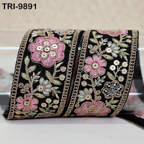 a decorative black fabric with a floral pattern and gold chain accents.