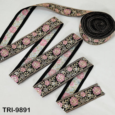 a collection of decorative fabric pieces, including a black and gold floral-patterned ribbon and a black and gold sequin ribbon.