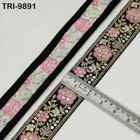 a decorative floral embroidered border with a ruler placed on top of it, indicating the size of the border.