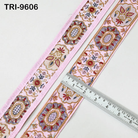 a pink and white decorative fabric with intricate floral patterns, and a ruler is placed next to it, indicating the size of the fabric.