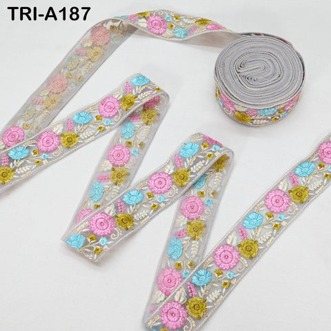 a collection of decorative fabric ribbons with floral patterns in shades of pink, blue, and yellow. The ribbons are arranged on a white background, with some of them rolled up and others laid out flat.