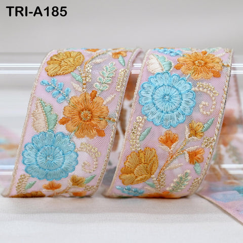 two decorative fabric pieces with intricate floral embroidery in shades of pink, blue, and orange. The pieces are arranged side by side, with the left piece slightly overlapping the right one.