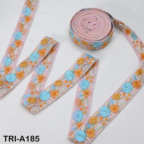 a collection of decorative fabric ribbons with floral patterns in shades of pink, blue, and orange. The ribbons are arranged on a white surface, with one ribbon lying flat and the others rolled up.