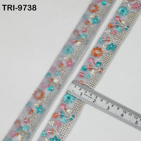 two pieces of fabric with a floral pattern, and a ruler is placed on top of them to measure their length.