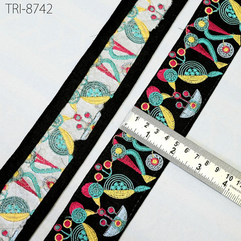 a close-up view of a colorful, patterned fabric with a ruler placed on top of it, indicating the size of the fabric.