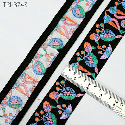 a close-up view of a decorative fabric with a colorful, intricate floral pattern. A ruler is placed on the fabric, indicating its size or dimensions.
