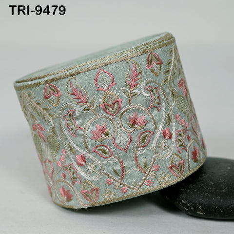 a decorative fabric with a floral pattern in shades of pink and green, and it appears to be a piece of clothing or accessory with a light blue or mint-colored background.
