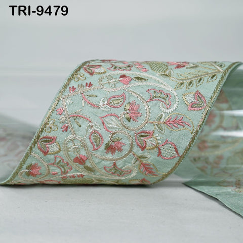A close-up image of a decorative fabric with a floral pattern in shades of green and pink.