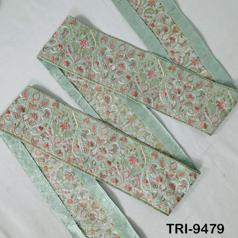 a decorative fabric with a floral pattern in shades of green and pink. The fabric appears to be a decorative trim or border, possibly used for embellishing a garment or accessory.