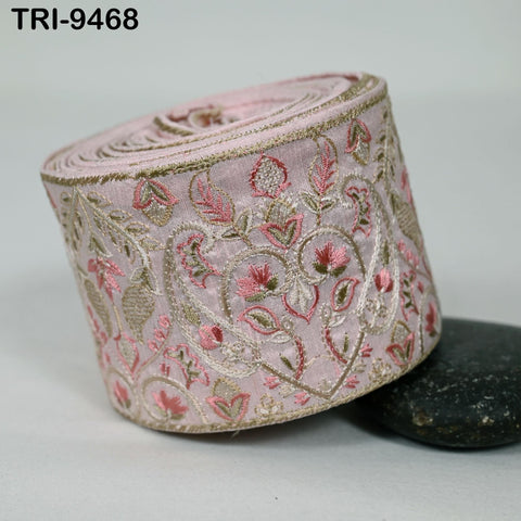 A close-up image of a decorative fabric with a floral pattern in shades of pink and gold.