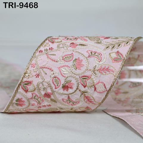 A close-up image of a decorative fabric with a floral pattern in shades of pink and gold.