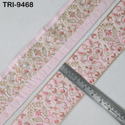 a close-up view of a decorative fabric with a floral pattern in shades of pink and gold. A ruler is placed on the fabric, indicating its size or dimensions.