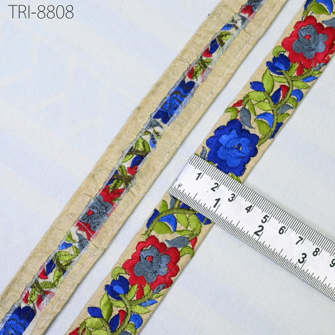a close-up view of a decorative fabric with a floral pattern, featuring a ruler for scale.