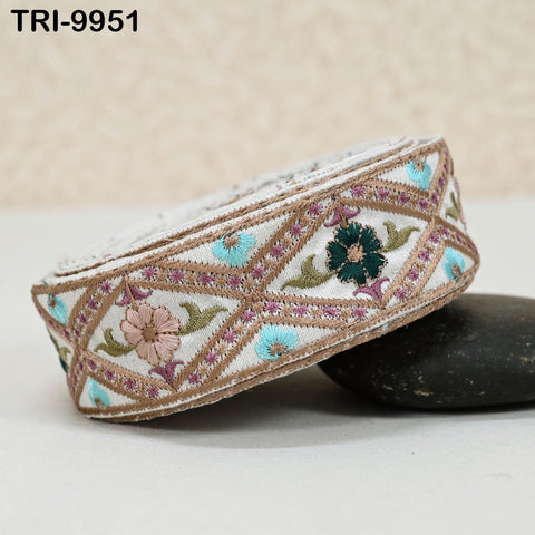 a decorative headpiece with a floral pattern and a geometric design, resting on a black surface.