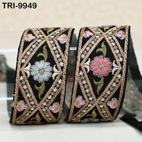 two decorative fabric pieces with intricate embroidered designs, including flowers and geometric patterns, displayed on a surface.