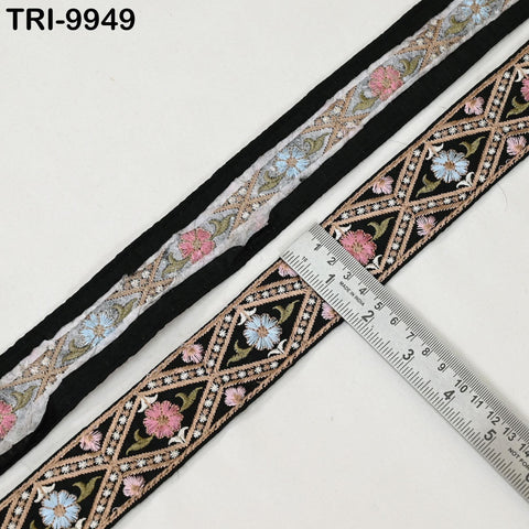 a decorative fabric with a floral pattern, and a ruler is placed next to it to measure the length of the fabric.