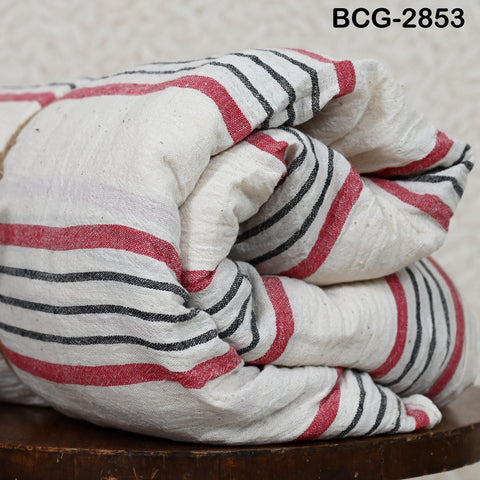 A folded blanket with red and black stripes is displayed on a wooden surface.