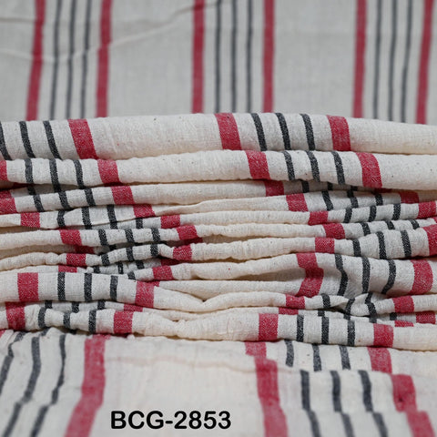 A close-up image of a stack of white and red striped fabric, with a blurred background.