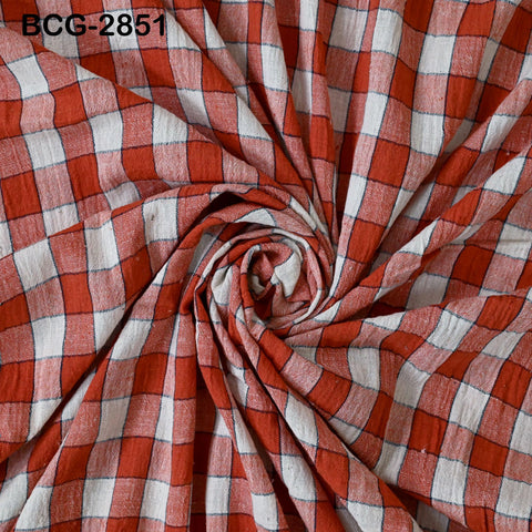 a close-up view of a fabric with a red and white checkered pattern, with the fabric appearing to be folded or twisted in a spiral motion.