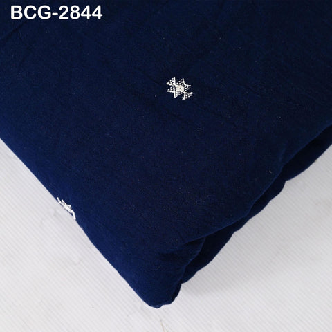 a close-up view of a dark blue fabric with a small white embroidered design on it.