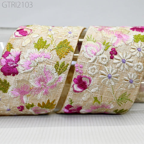 two pieces of fabric with a floral pattern, featuring pink and white flowers and green leaves. The fabric appears to be made of a light-colored material, possibly cotton or linen.