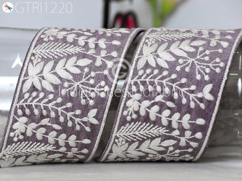 two pieces of fabric with a floral pattern, including white flowers and leaves, arranged on a surface.