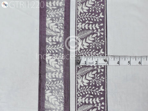 two pieces of fabric with a decorative purple and white floral pattern. A ruler is placed between the two pieces of fabric, indicating their size.