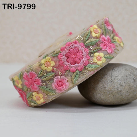 a decorative fabric with a floral pattern, including pink and yellow flowers, placed on a white surface.