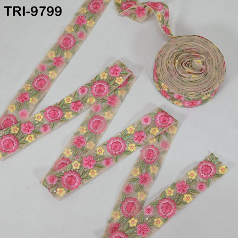 a collection of floral embroidered fabric pieces, including a large piece with a pink and yellow floral pattern and a smaller piece with a similar floral design. The pieces are arranged on a white background, creating a visually appealing display.