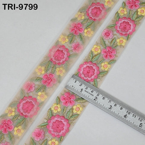 a decorative fabric with a floral pattern, featuring pink and yellow flowers. A ruler is placed on the fabric, indicating its size.