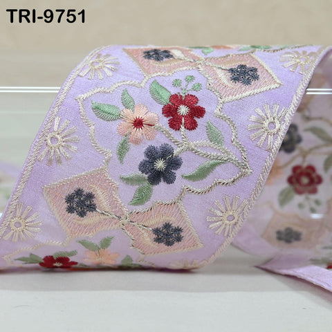 a close-up view of a decorative fabric with a floral pattern, featuring various shades of pink, purple, and green.