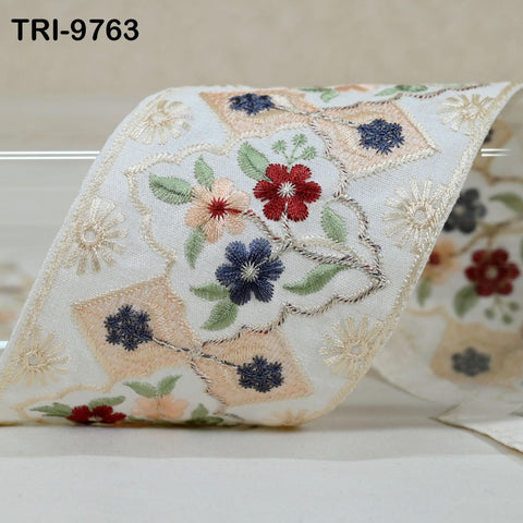 a close-up view of a decorative fabric with a floral pattern, featuring various colors and shapes.