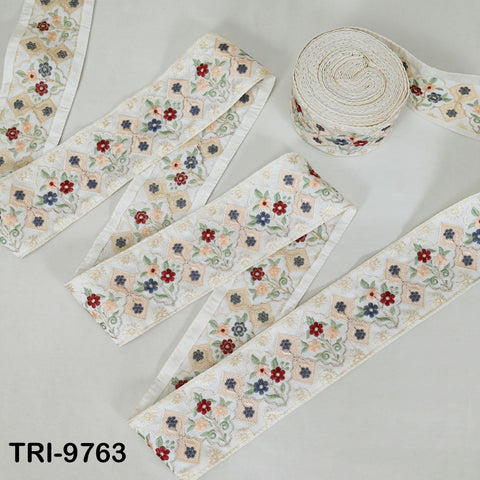 several rolls of fabric with a floral pattern, including a large roll and smaller rolls arranged on a white surface.