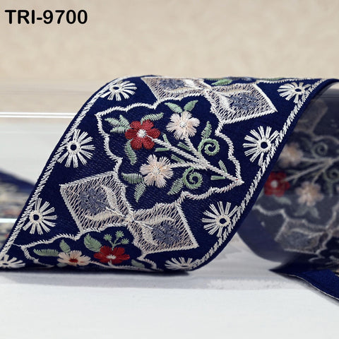 a close-up view of a decorative blue fabric with intricate floral embroidery.