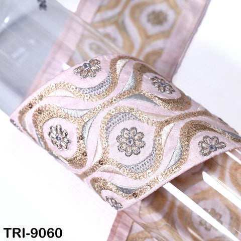 a close-up view of a decorative fabric with a floral pattern in shades of pink and gold.