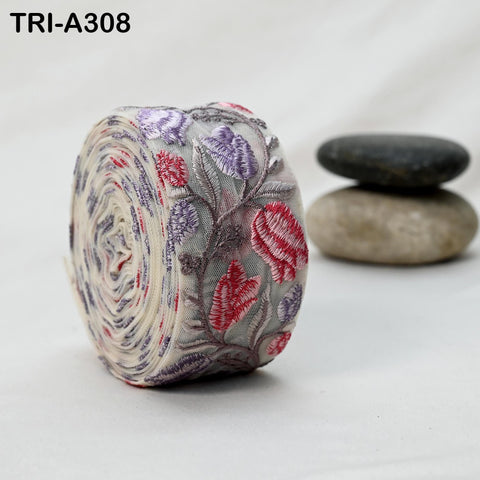 a close-up of a fabric with a floral pattern, including red and purple flowers, against a plain white background.