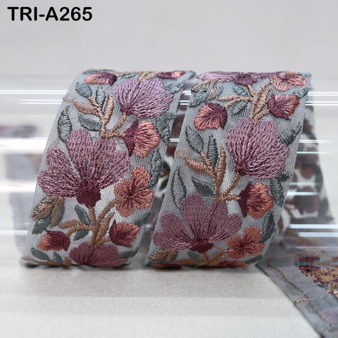 a decorative fabric with a floral pattern, featuring a variety of pink and purple flowers arranged in a repeating design.