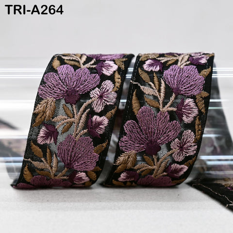 two decorative fabric pieces with a floral pattern in shades of purple and brown. The pieces appear to be made of a shiny material, possibly lace or silk, and are displayed against a plain background.