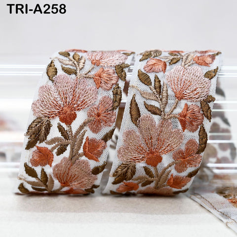 two pieces of fabric with a floral pattern, including pink and brown flowers, arranged in a curved fashion.