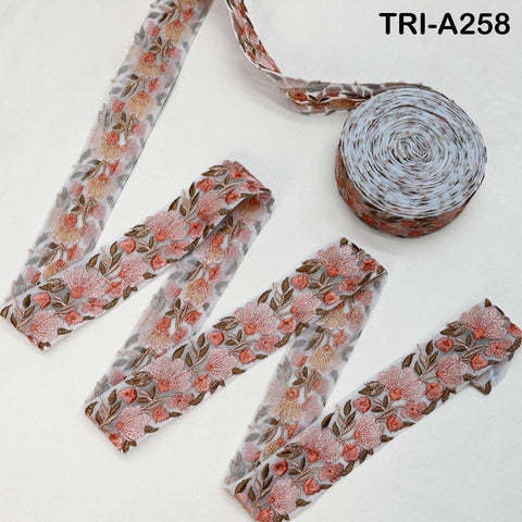 a floral print ribbon and a spool of ribbon with a floral pattern, both placed on a white background.