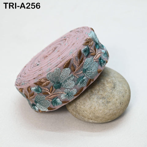 a pink fabric with a floral pattern, resting on a gray rock.