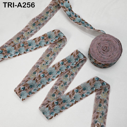 a spool of pink and blue floral embroidery thread and several spools of the same thread, arranged on a white background.
